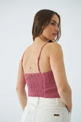 Top corto de dama con tirantes finos ajustables, confeccionado en tejido de textura natural con costuras decorativas en el frente y grifa de cuero.