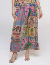Vestido largo sin mangas de gasa color rosa, con estampado tipo patchwork tropical que incluye piñas, flamencos y motivos botánicos. Cuenta con un pronunciado escote en V y cintura elastizada.