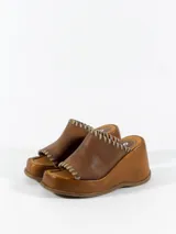 Sandalia de cuero color tostado, con plataforma y detalle de costuras en la capellada.