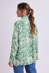 Camisa de manga larga con cuello clásico y estampado floral en tonos verde y blanco.