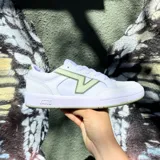 Championes Vans modelo Lowland, de diseño urbano en color blanco con detalles en verde claro. Presentan el logo lateral característico de la marca, puntera perforada y suela de goma.