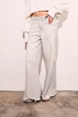 Pantalón de jean celeste de corte wide leg con terminación desflecada.