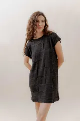 Vestido corto negro con diseño tejido en bloques, de mangas cortas y corte recto.