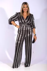 Mono largo plisado con rayas verticales plateadas y negras, con escote cruzado, mangas 3/4 abullonadas y cinturón incorporado.