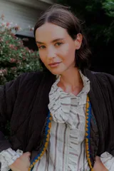 Camisa de corte clásico con estampado de rayas verticales, cuello alto con volados frontales y mangas largas con puños con volados.