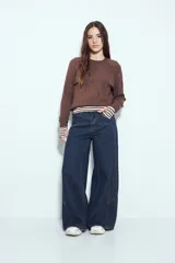 Sweater de punto color negro, con cuello redondo y diseño texturizado con ondas en relieve. Presenta mangas largas y un calce cómodo y holgado.