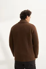 Cardigan marrón tejido con cuello smoking, cierre con botón y bolsillos delanteros.