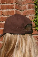 Gorra marrón de algodón con logo bordado en celeste en el frente y ganchito ajustable en la parte trasera.