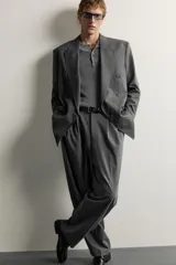 Blazer gris de corte relaxed fit con diseño de raya diplomática, cuello con solapas de pico, doble botonadura cruzada y bolsillos con solapa en la cadera.