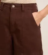 Short de mujer de sarga color beige claro, tiro alto, con pespunte contrastante en color blanco o crema. Presenta un corte regular y bolsillos delanteros y traseros.