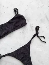 Conjunto de bikini color turquesa con tejido acanalado. El corpiño es tipo bandó con breteles finos regulables y espalda ajustable. La bombacha es vedetina con tiras ajustables a los costados.