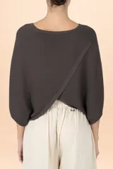 Poncho de tejido de punto en color café oscuro, con diseño fluido y corte holgado.