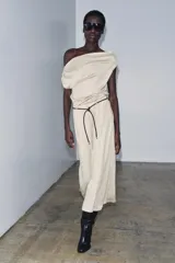 Top de tejido punto color marrón oscuro, con escote asimétrico tipo *one-shoulder* y drapeado frontal.