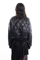 Campera bomber negra de tela satinada con bordado rojo en el pecho. Es reversible.