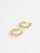 Aros tipo argollas de acero quirúrgico con acabado dorado y diseño plano.