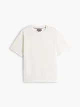 Remera de punto de algodón moteado, color blanco, con cuello redondo y escudo con monograma TH bordado en tono sobre tono en el pecho. Presenta un corte amplio y cómodo.