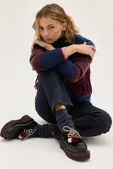 Borcego de cuero color bordó con suela de plataforma, cordones bicolores y detalle de pompones decorativos en el empeine.