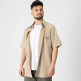 Camisa de manga corta color beige, con cuello clásico, cierre con botones y corte regular.