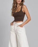 Pantalón jean de corte wide leg y tiro alto, color blanco, con diseño de costuras decorativas frontales y bolsillos laterales y traseros.