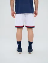 Short deportivo Umbro del Club Nacional de Football, modelo Match para hombre. Diseño en color azul marino con tejido de malla, detalles en blanco y rojo en los laterales y el escudo del club bordado.