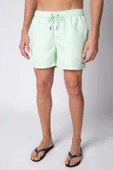 Short de baño color verde menta con efecto desgastado, cintura elástica con cordón ajustable y bolsillos laterales.