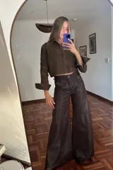 Pantalón de cuero marrón de corte palazzo con paneles y costuras a la vista.