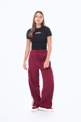 Pantalón cargo de corte amplio, color negro, con franjas laterales blancas y bolsillos tipo cargo en los costados. Presenta cintura elástica con cordón ajustable.