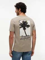 Remera de manga corta y cuello redondo en color caqui, confeccionada en puro algodón, con sutil logo bordado en el pecho y etiqueta distintiva en la manga.