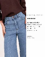 Jean wide leg de tiro medio en color azul claro, con diseño amplio y fluido en las piernas, bolsillos delanteros y traseros tradicionales, y cierre frontal con botón y cremallera.