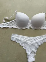 Conjunto de lencería compuesto por un corpiño taza soft de microfibra con detalles de puntilla y una bombacha tipo less a juego con laterales de encaje.