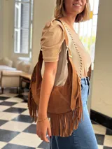 Cartera bandolera de cuero color camel con flecos largos en la parte inferior.