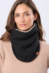 Cuello de abrigo reversible, confeccionado en tejido polar negro en una cara y tejido tipo sherpa color crema en la otra. Presenta una pequeña etiqueta de cuero sintético con logo grabado.