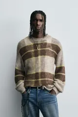 Jersey de punto con estructura abierta y calce relajado. Presenta cuello redondo, manga larga y diseño a rayas horizontales en tonos marrón y gris con detalles en amarillo neón. Acabados en rib en puños y ruedo.