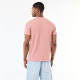 Camiseta de cuello redondo y manga corta color rosado, con textura en nido de abeja y pequeña etiqueta decorativa en el dobladillo.