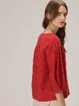 Blusa roja de algodón, con mangas largas abullonadas y diseño holgado.
