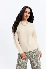 Buzo de punto negro con cuello redondo, manga larga y textura sutil. Presenta un diseño minimalista y versátil, ideal para combinar en diversas ocasiones.