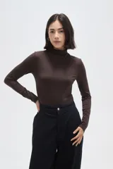 Polera de poliamida color marrón, de corte ajustado al cuerpo, con cuello alto y mangas largas.