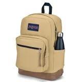 Mochila JanSport color arena con base de gamuza marrón. Tiene un compartimento principal con cierre, un bolsillo frontal con cierre, un compartimento interno acolchado para laptop y un asa de mano en la parte superior.