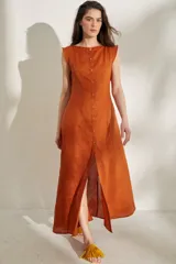 Vestido largo sin mangas de lino color naranja, con escote bote y hilera de botones frontales que forman una abertura en la falda.