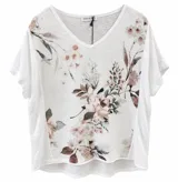 Blusa blanca de manga corta y cuello en V con delicado estampado de hojas y flores en tonos beige y rosado, de corte holgado.