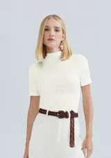 Blusa de punto acanalado color blanco off-white, de corte ajustado, con mangas cortas y cuello alto.