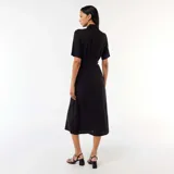 Vestido midi negro de estilo camisero, con cuello camisero, mangas cortas, cierre frontal de botones y cinturón ajustable para anudar en la cintura.