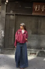 Campera tipo bomber color bordó, confeccionada en gamuza, con cierre frontal y bordados decorativos en el pecho y las mangas. Presenta un diseño holgado con puños y cuello clásico.