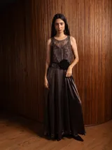 Top sin mangas de encaje con diseño floral, con escote redondo y base de satén en tono violeta oscuro.
