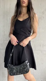 Vestido corto negro con breteles finos y escote cruzado.
