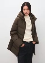 Parka acolchada color marrón chocolate, con diseño puffer, capucha integrada, cierre frontal y bolsillos laterales.