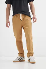 Pantalón de gabardina color ocre, con corte recto, cintura elastizada con cordón ajustable y bolsillos laterales.