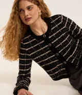 Cardigan cropped negro con diseño de tweed a cuadros blancos, con cuello redondo y cierre frontal con botones esmaltados.