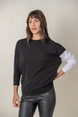 Remera negra de algodón con una manga larga blanca y corte holgado.