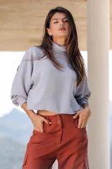 Blusa celeste con cuello alto, mangas 3/4 abullonadas y corte cropped.